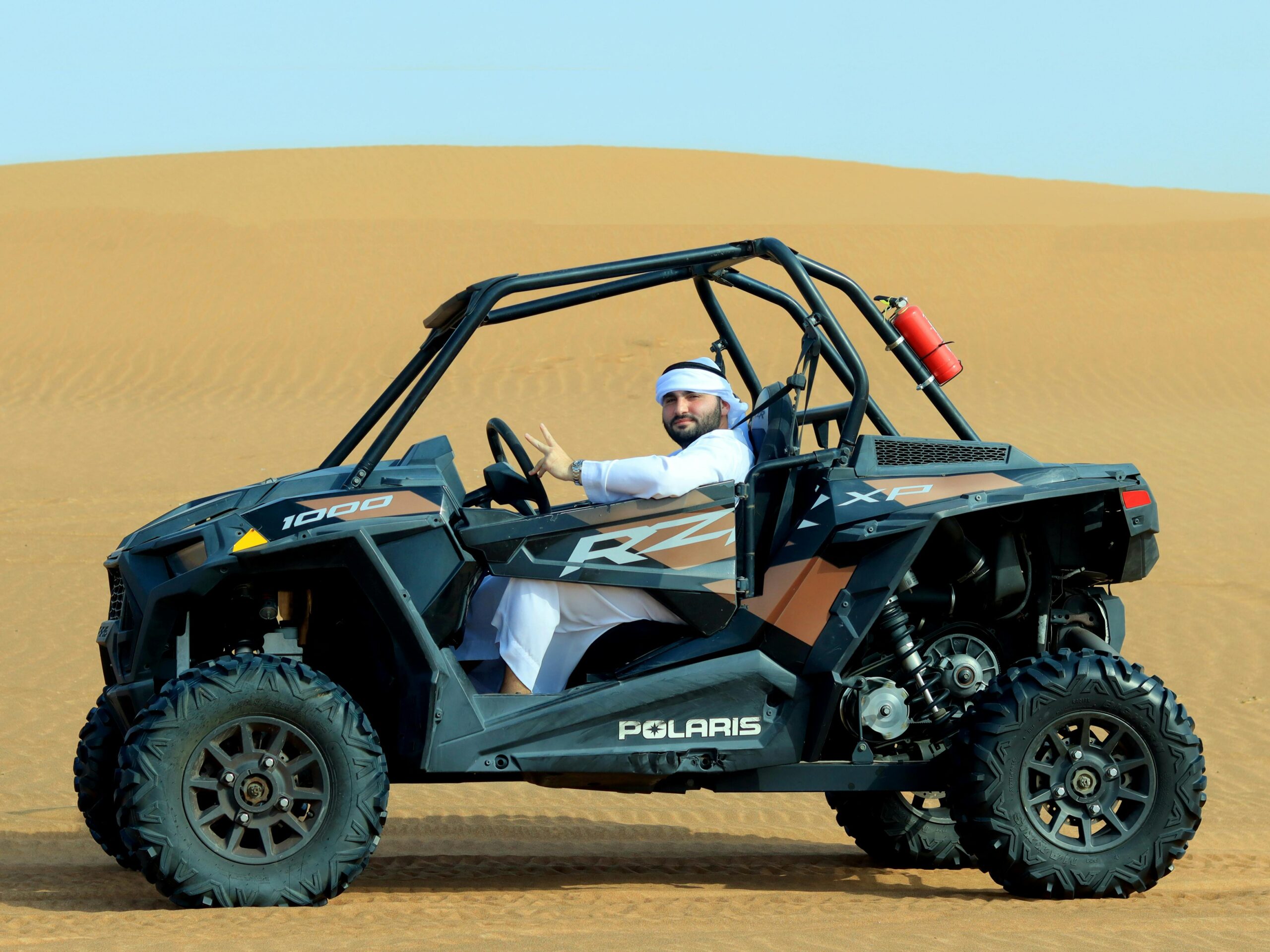 Man driving an ATV through the Dubai desert dunes, experiencing thrilling off-road adventure.
